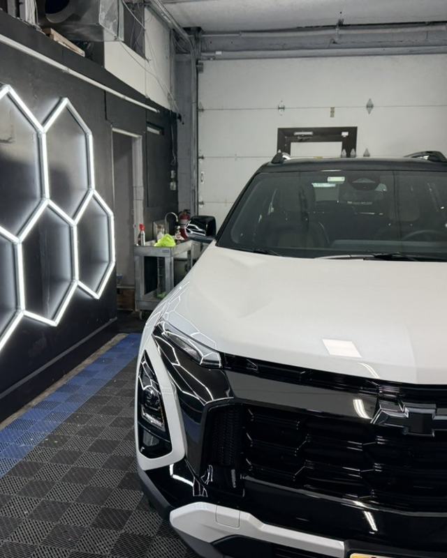 White Chevrolet SUV in the Zephyr Customz studio bay