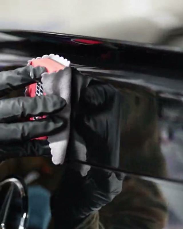 Coating being wiped onto glossy black paint